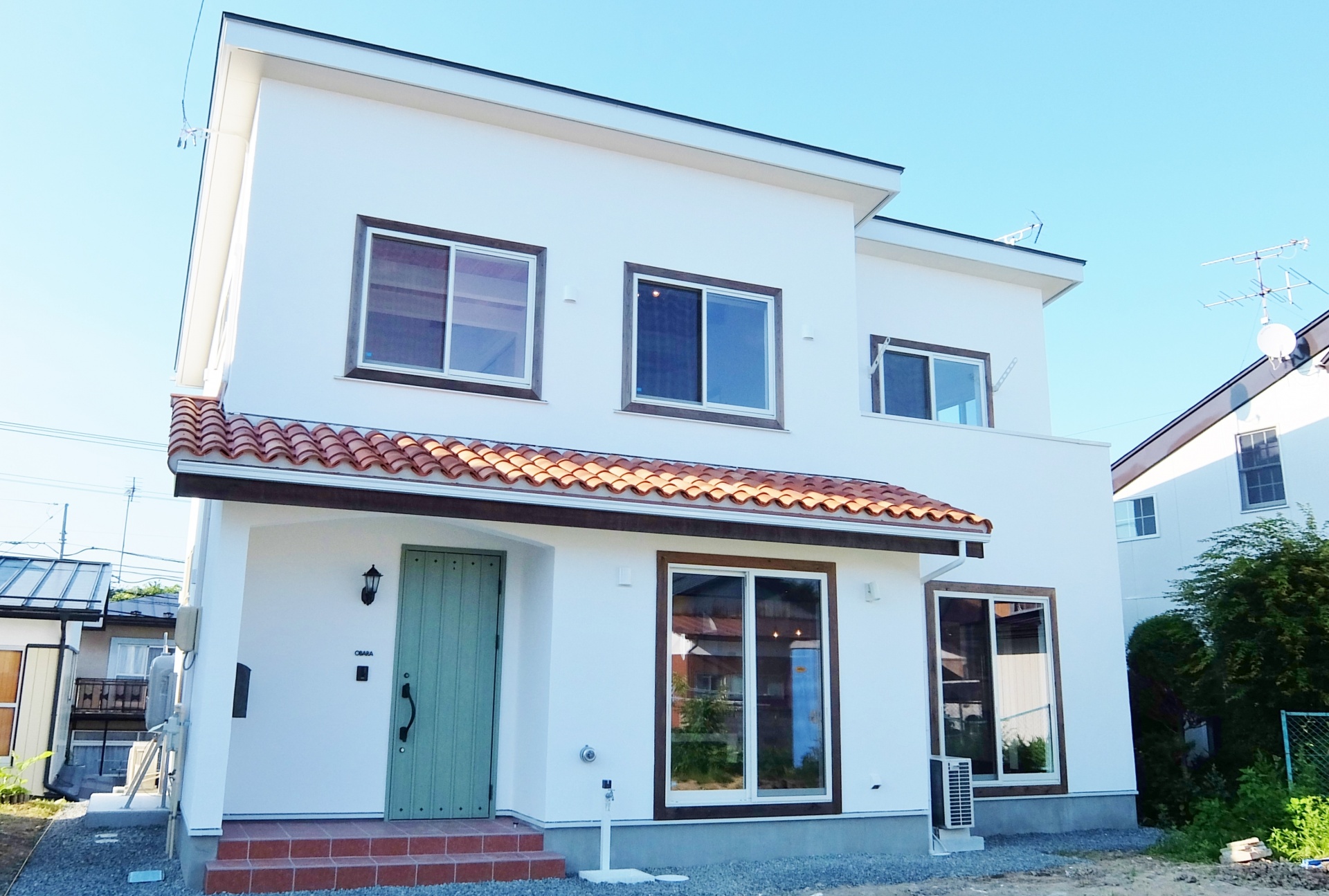 フランス瓦が特徴で濃いブラウンに塗装した無垢材と壁の白さを対照的にマッチした無添加住宅。 画像