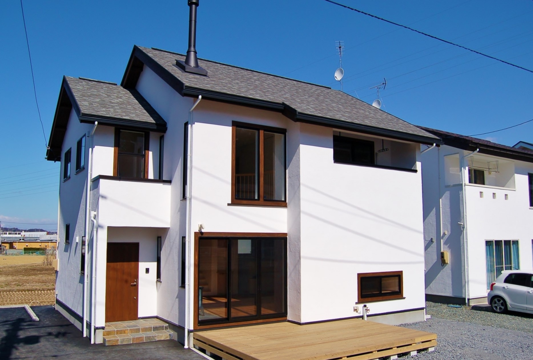 薪ストーブの煙突とウッドデッキが目を引き、漆喰壁との相性抜群な外観と和の空間もステキな無添加住宅へ。 画像